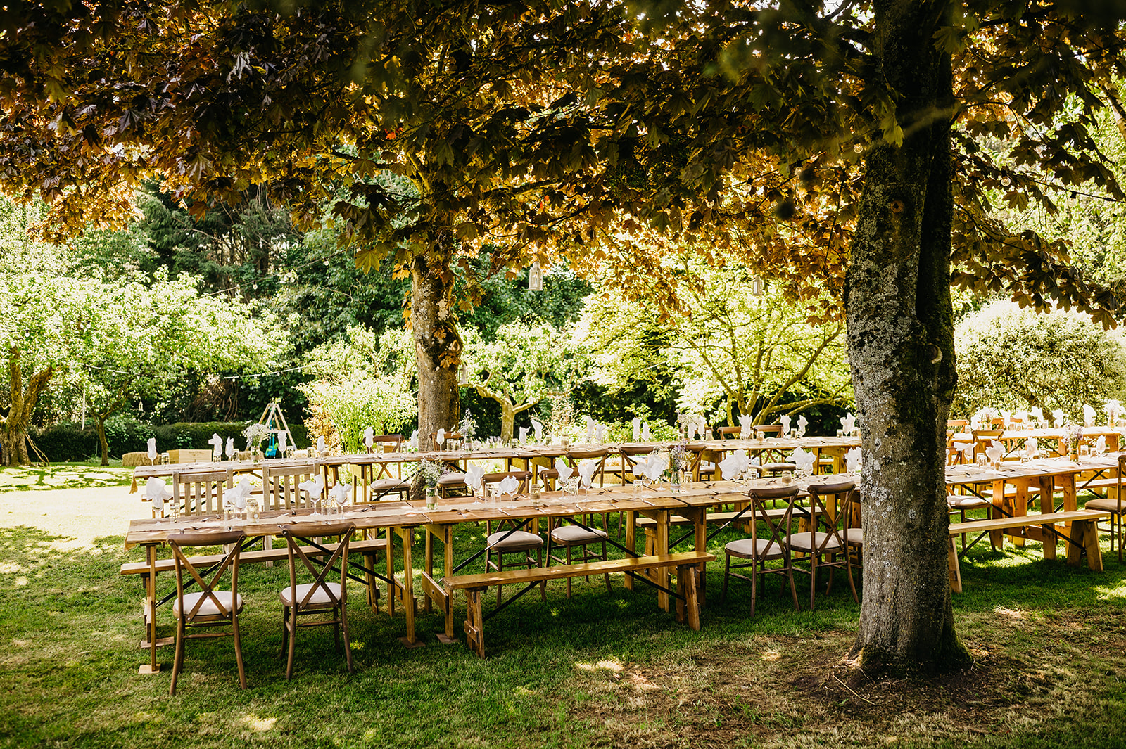 decorated wedding tables under garden trees