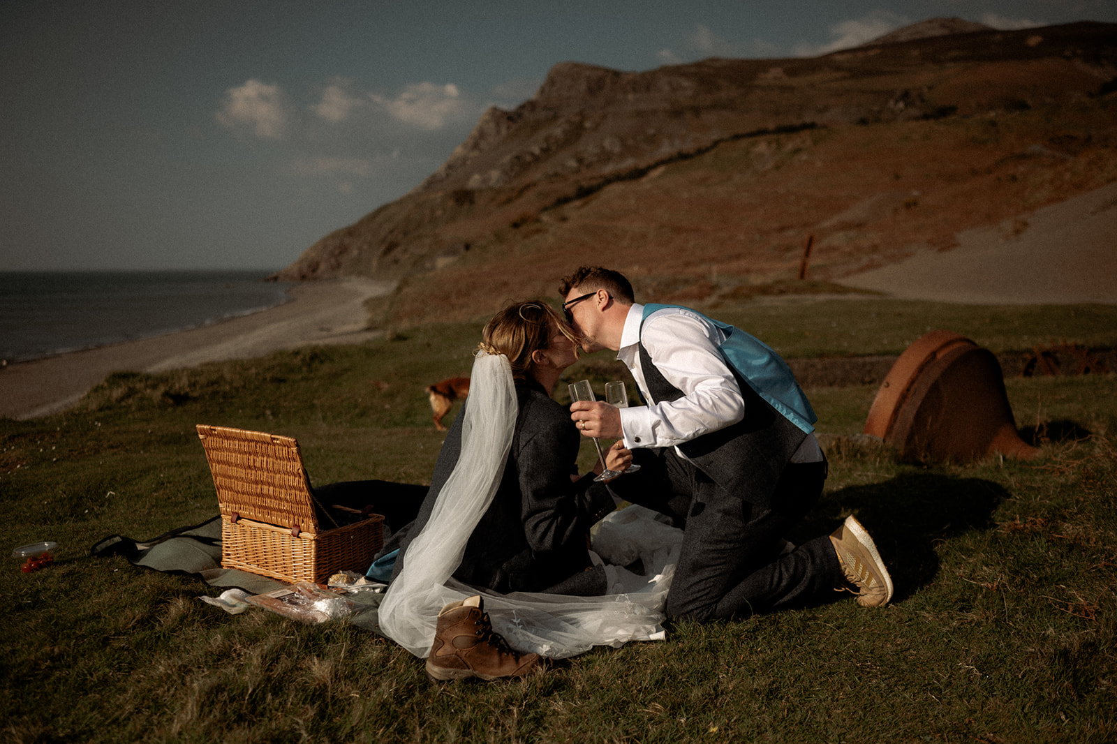 a bride and groom kissing during a picnic on their elopement wedding day in Wales