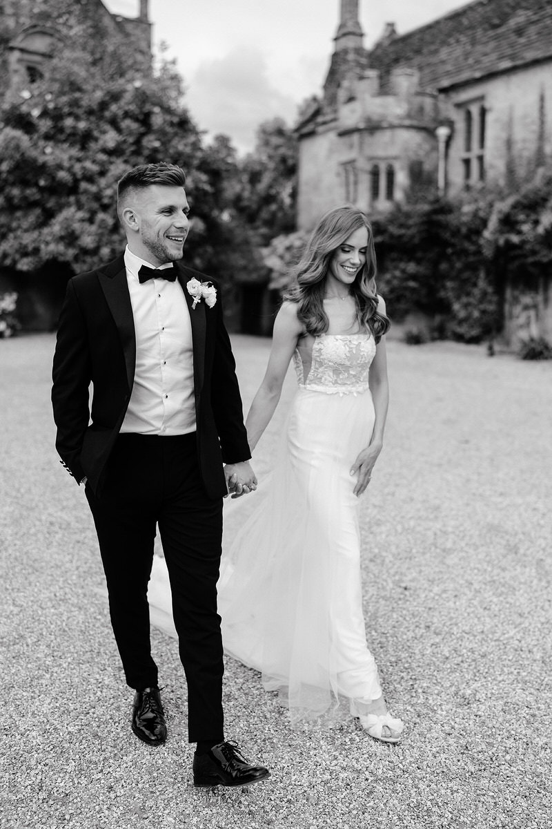bride and groom walk hand in hand at Brympton House
