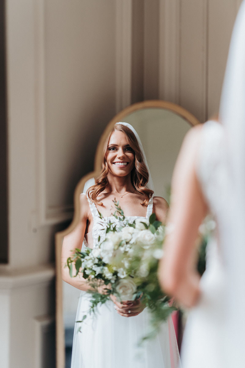 Bride looking in the mirror at Brympton House 