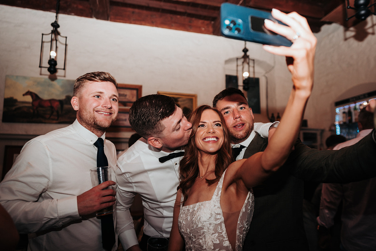 bride posing for a selfie with guests