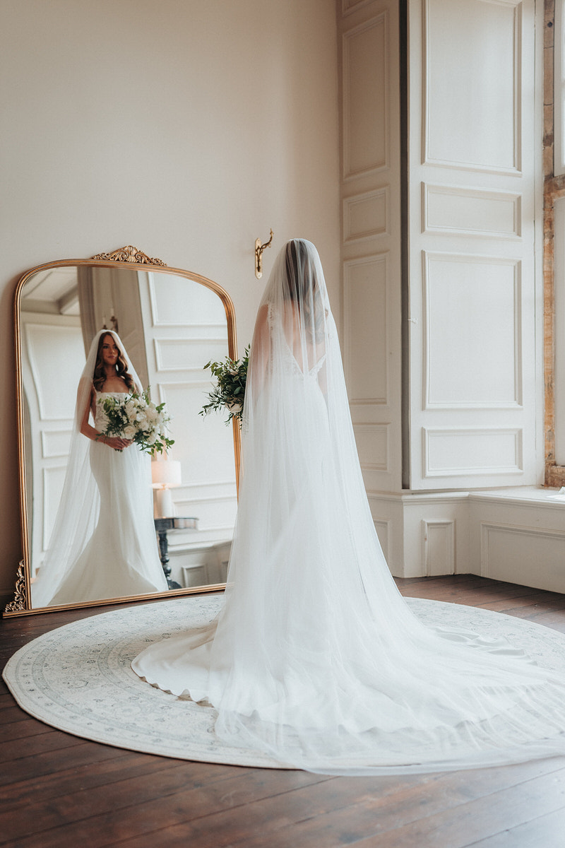 bride posing in the mirror for wedding videographer and photographer at Brympton House 