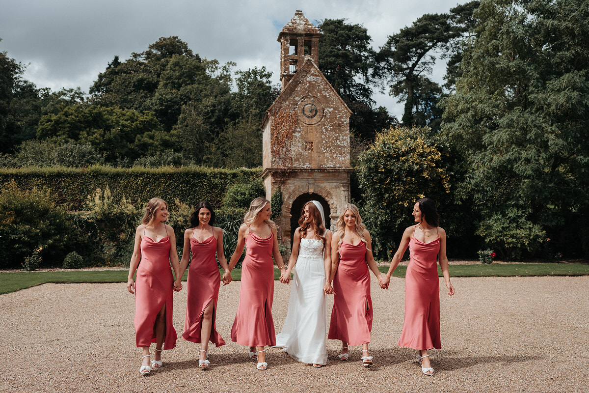 bridesmaids and bride walking together for a wedding photographer at Brympton House