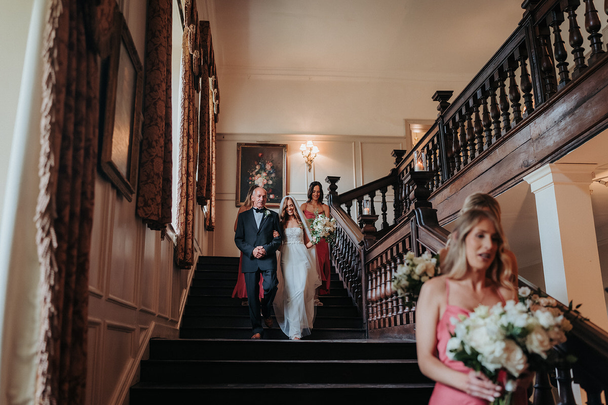 the bridal party walking down the stairs at Brympton House 