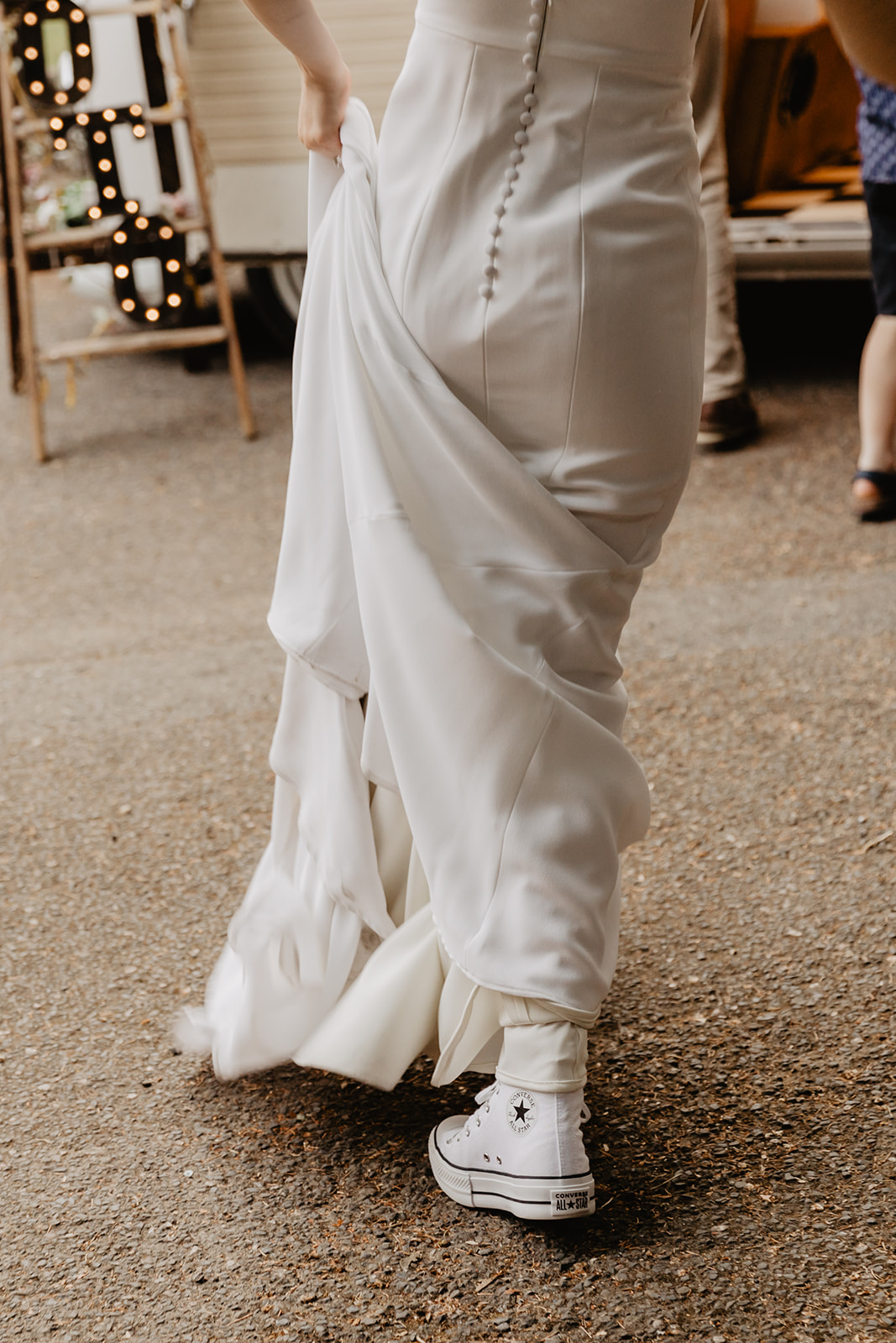 Bride dancing in converses at a Bury Manor Barn Wedding in Sussex. Photographer OliveJoy Photography.