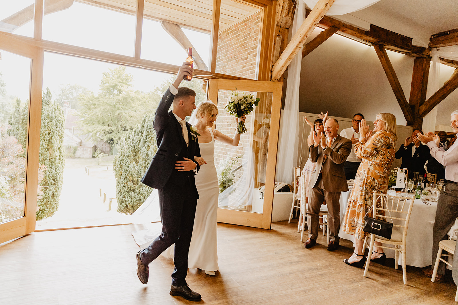 Bride and groom returning to reception venue at a Bury Manor Barn Wedding in Sussex. Photographer OliveJoy Photography.