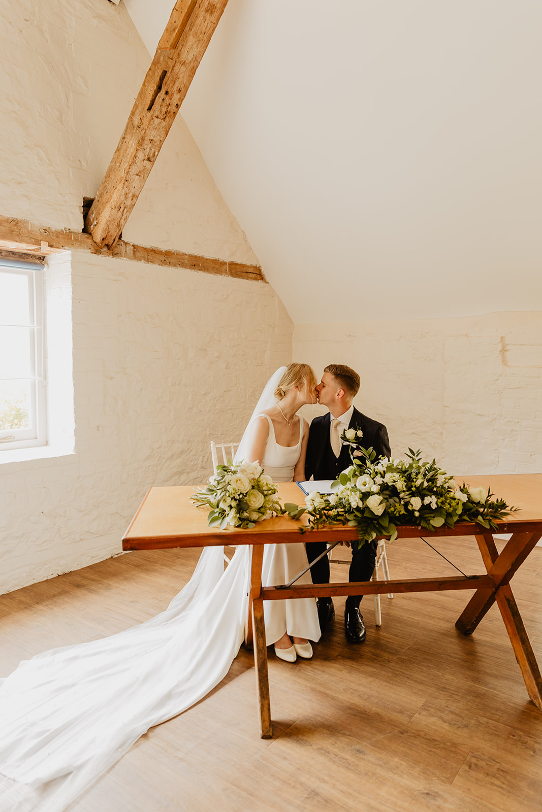Bride and groom signing the register at a Bury Manor Barn Wedding in Sussex. Photographer OliveJoy Photography.