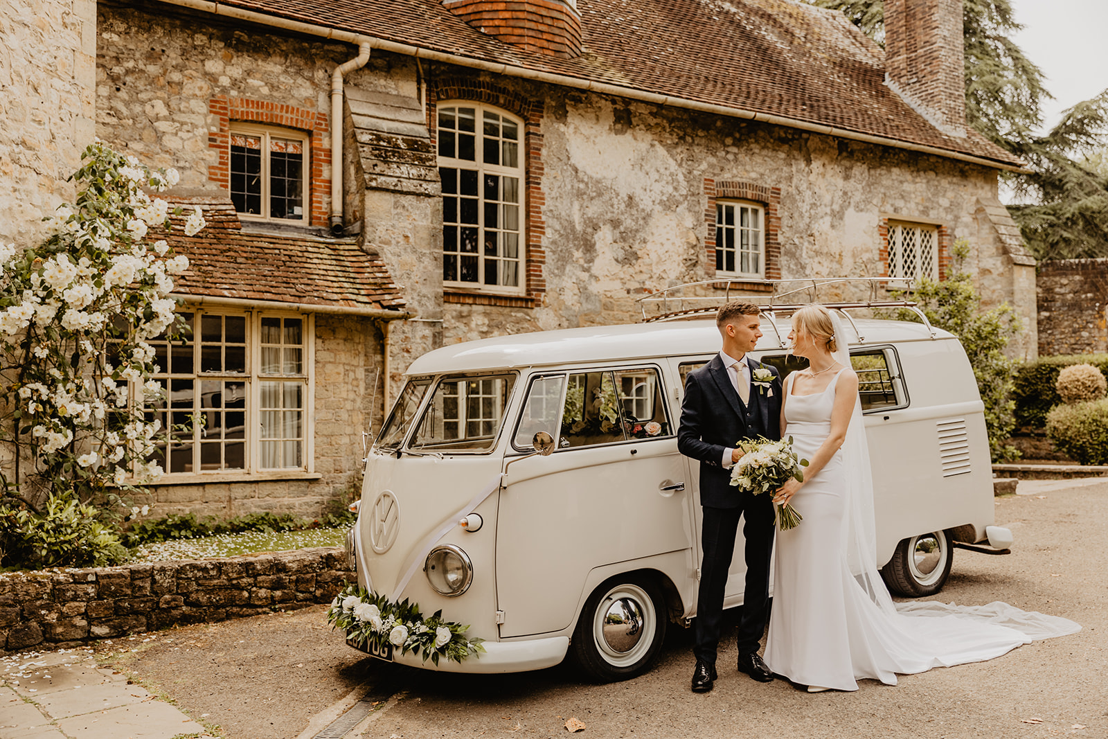 Bride and groom by VW camper at a Bury Manor Barn Wedding in Sussex. Photographer OliveJoy Photography.