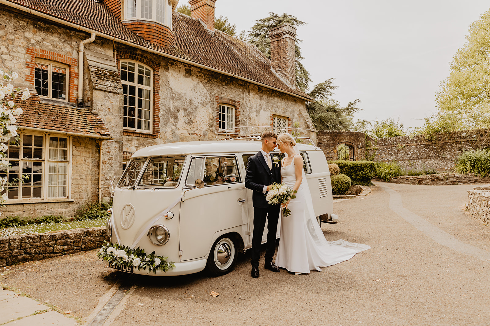 Bride and groom by VW camper at a Bury Manor Barn Wedding in Sussex. Photographer OliveJoy Photography.