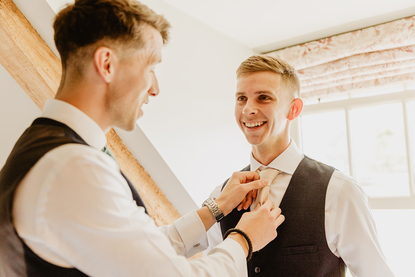 Groom having his tie tied at a Bury Manor Barn Wedding in Sussex. Photographer OliveJoy Photography.