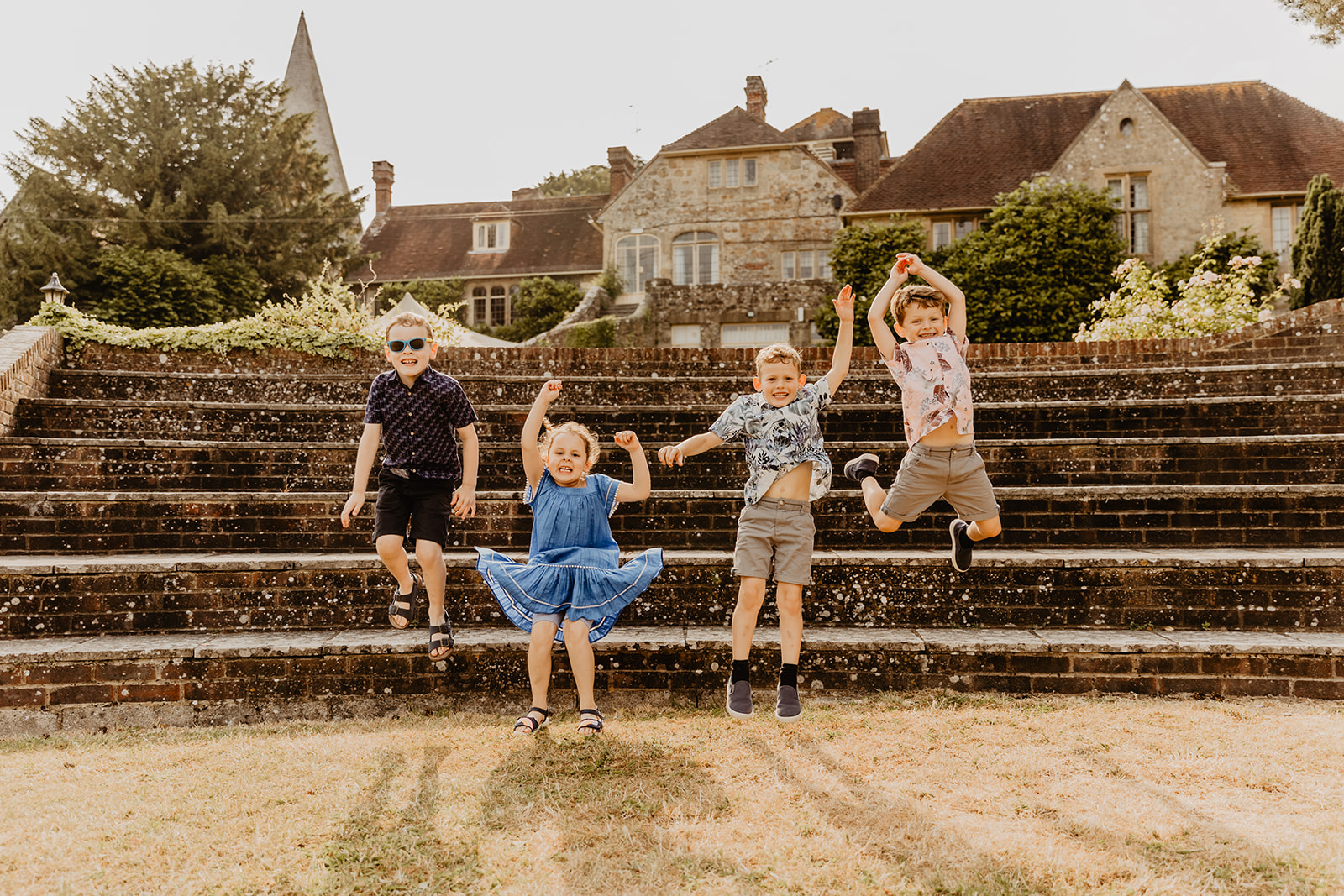 Kids jumping off steps at a Bury Manor Barn Wedding in Sussex. Photographer OliveJoy Photography.
