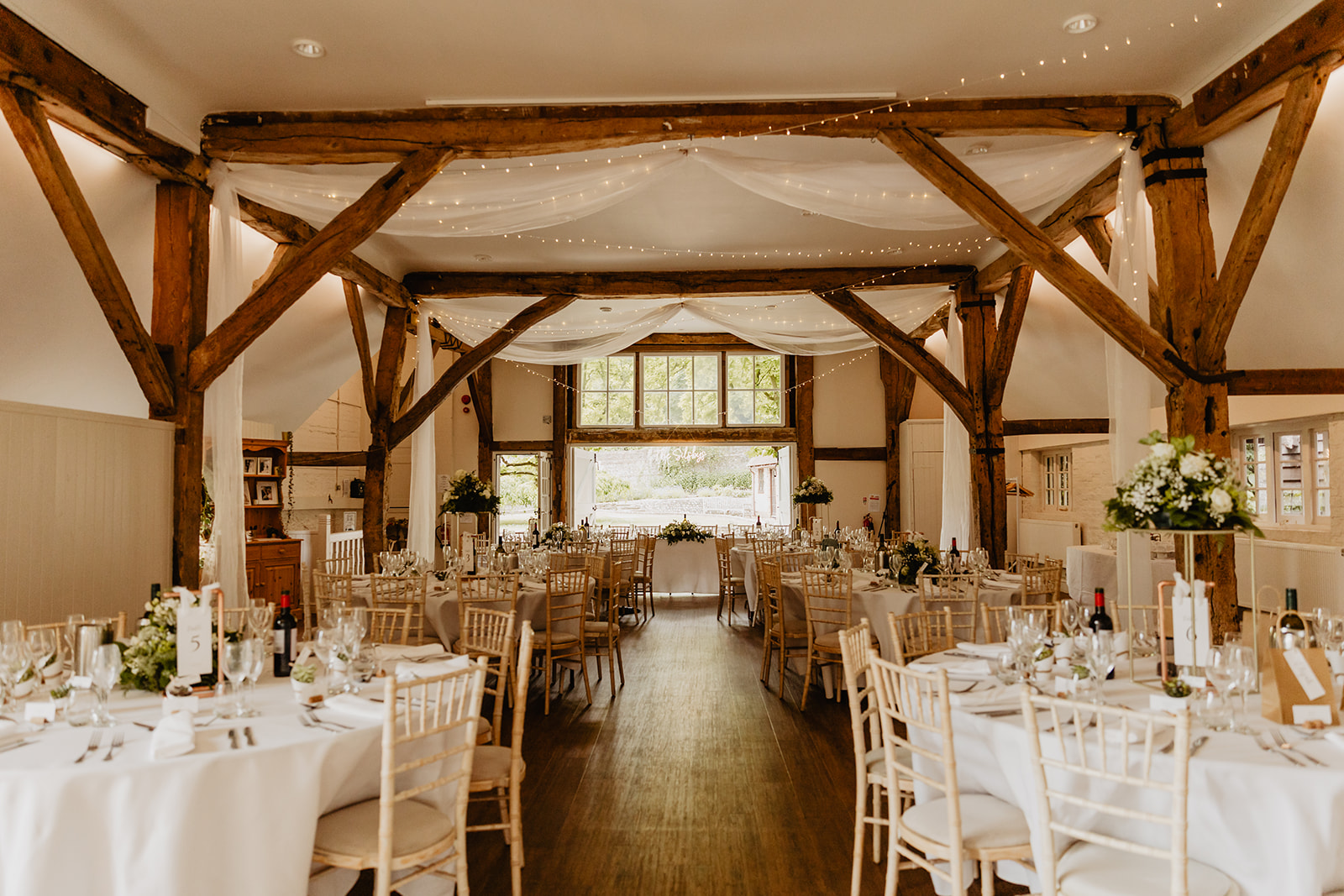 Wedding reception room at a Bury Manor Barn Wedding in Sussex. Photographer OliveJoy Photography.
