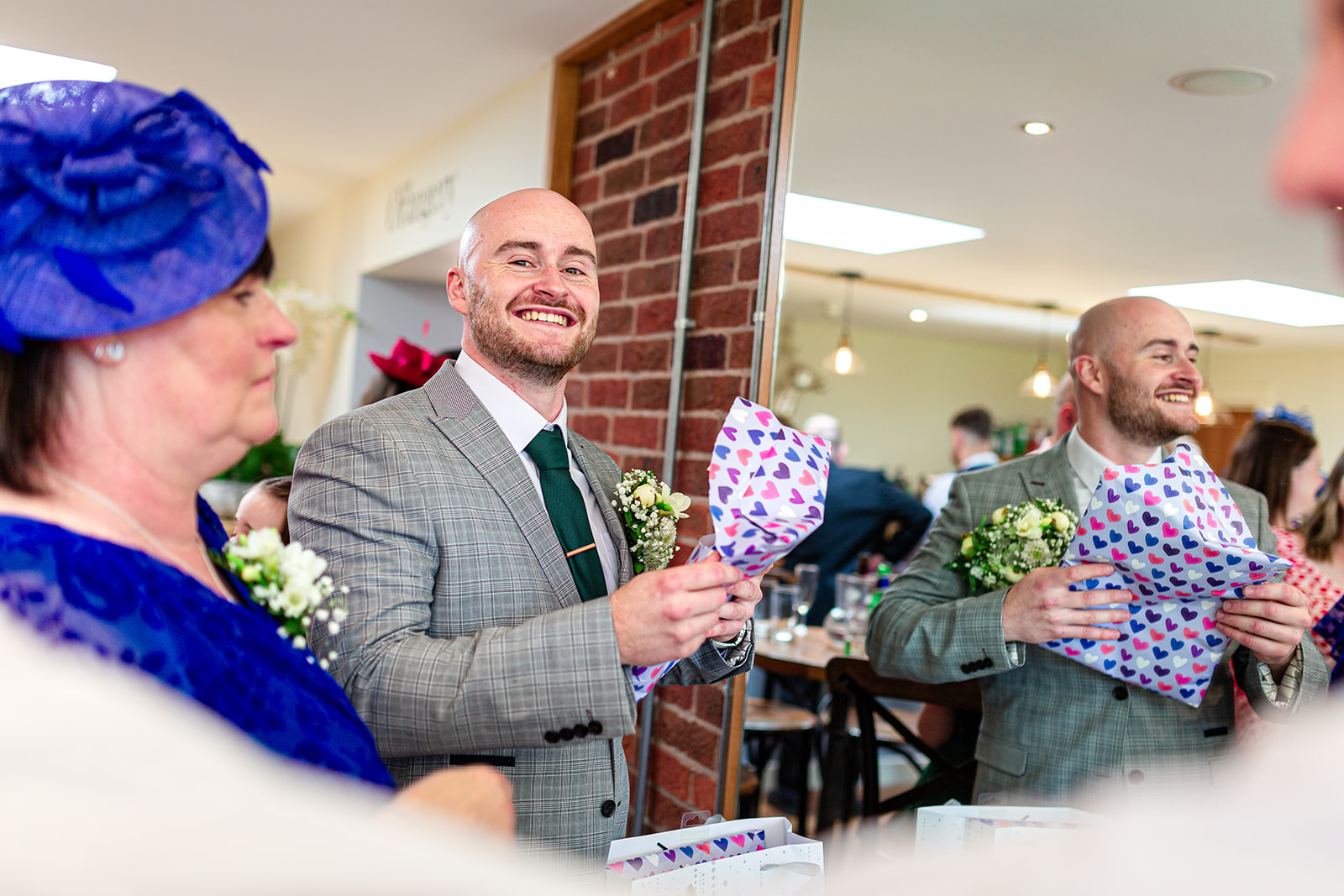 groom opening a gift from his fiance just before getting married at Bredenbury Court Barns