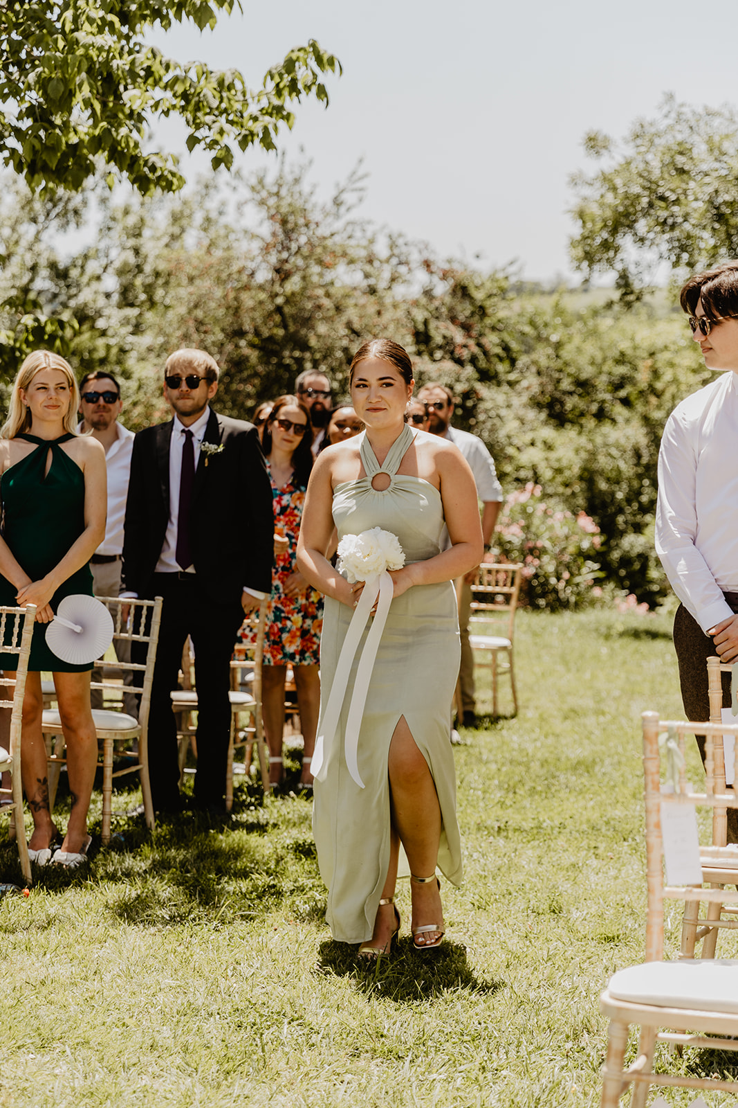 A bridesmaid walks down the aisle at a Destination Wedding in France. Photography & Videography by OliveJoy Photography