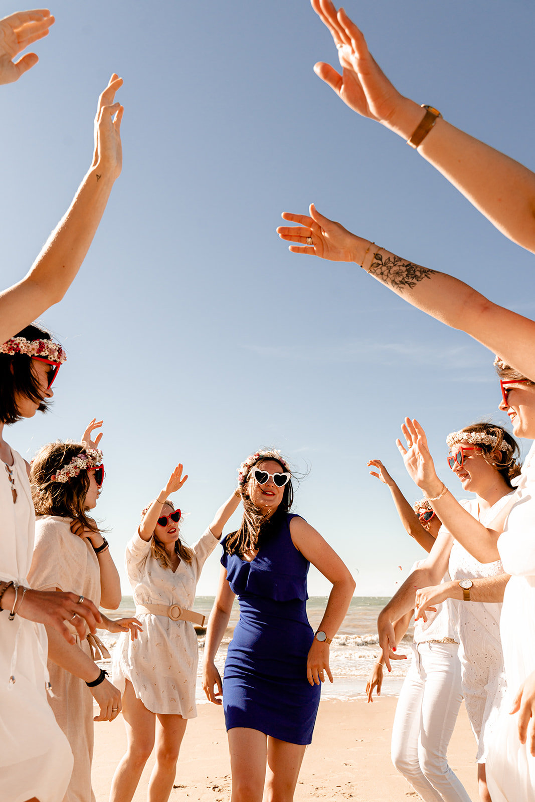 Future mariée souriante portant une robe bleue élégante sur la plage de l'Île de Ré.