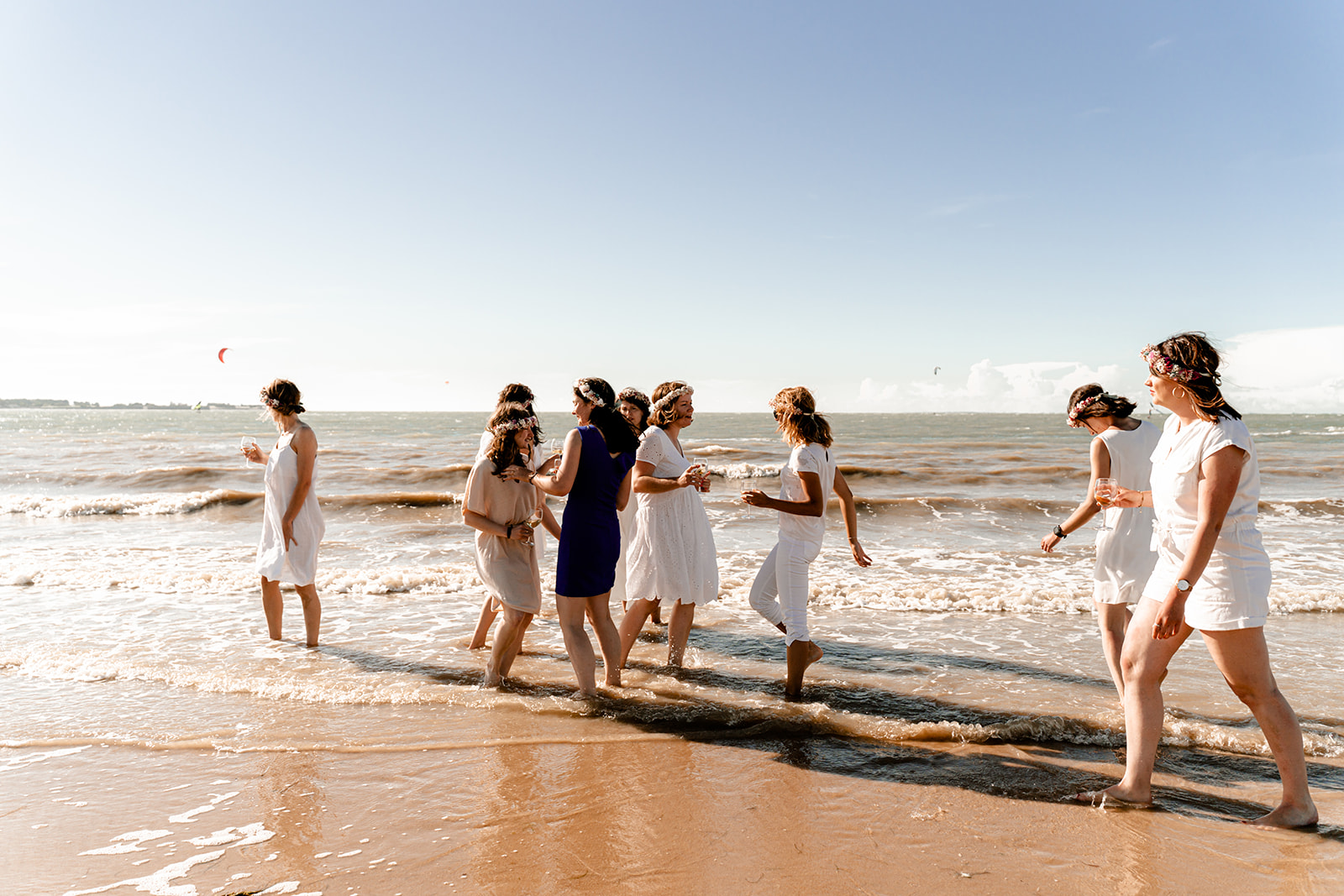 Groupe d'amies trinquant avec du champagne les pieds dans l'eau lors d'un EVJF à l'Île de Ré