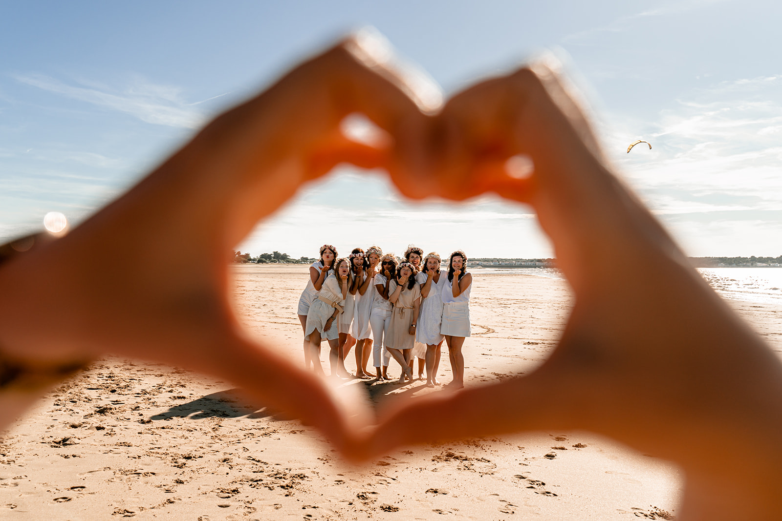 Groupe de jeunes femmes en robes d'été blanches riant ensemble sur une plage de l'Île de Ré.