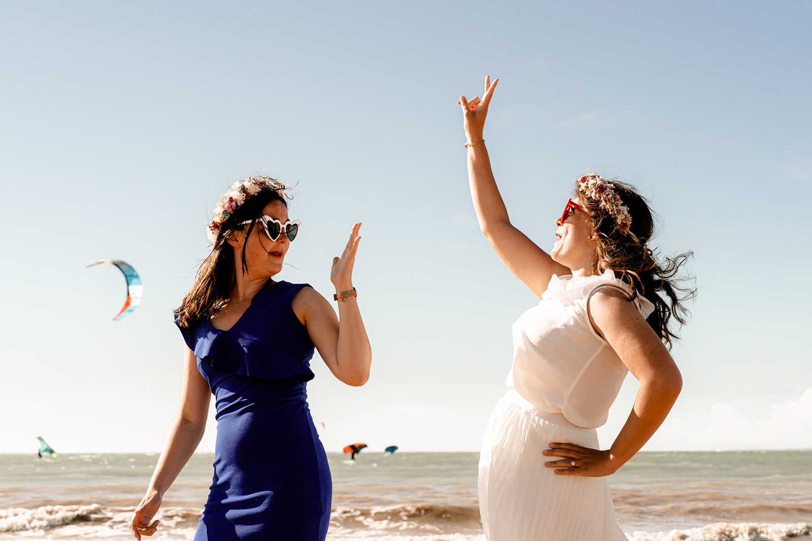 Groupe de jeunes femmes en robes d'été blanches riant ensemble sur une plage de l'Île de Ré