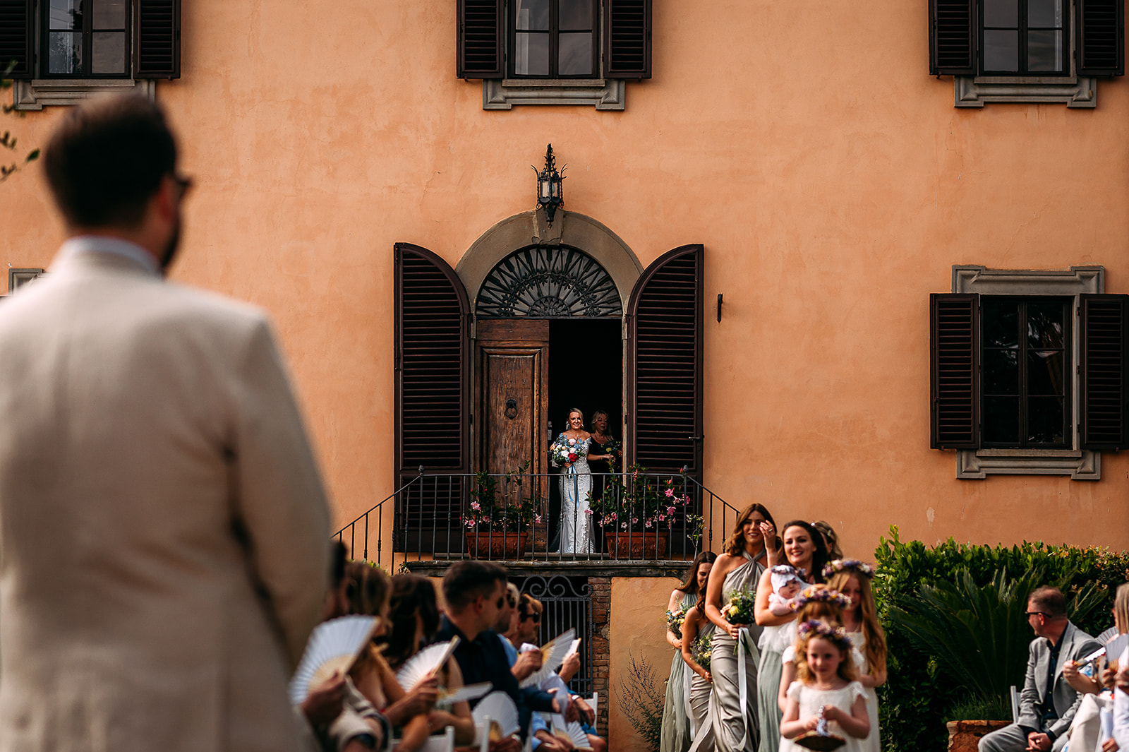 Bride walks out of the villa and down the steps to the wedding ceremony