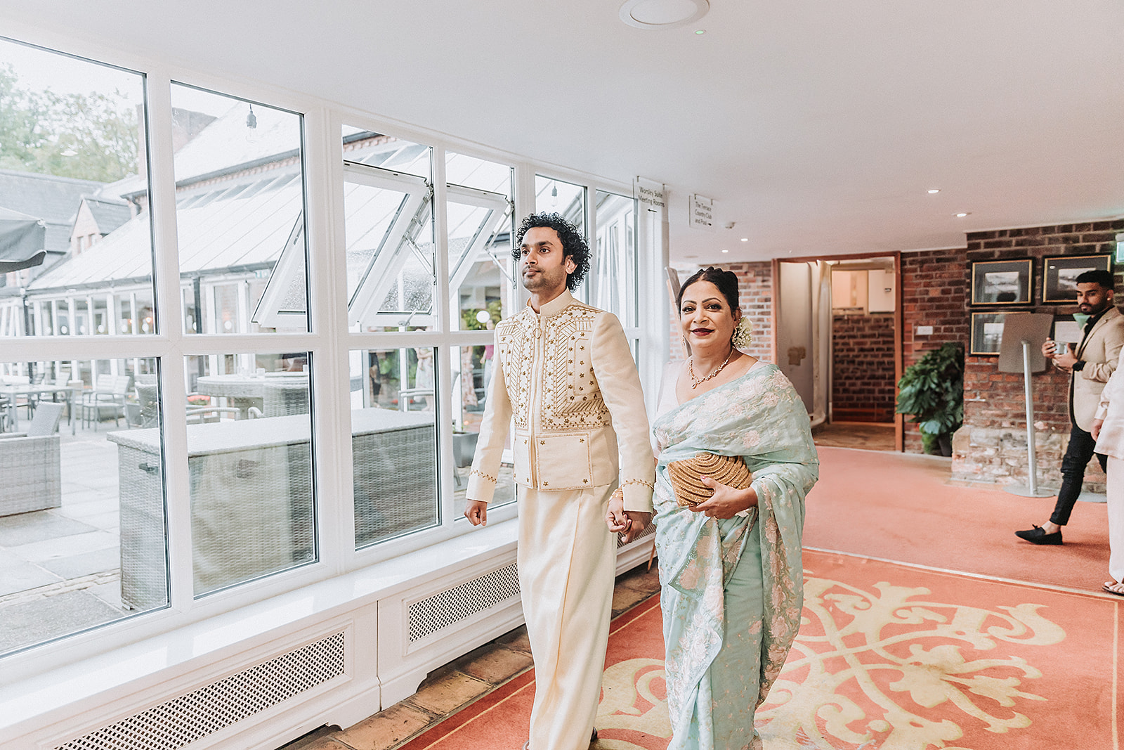 groom and mother walking into wedding venue