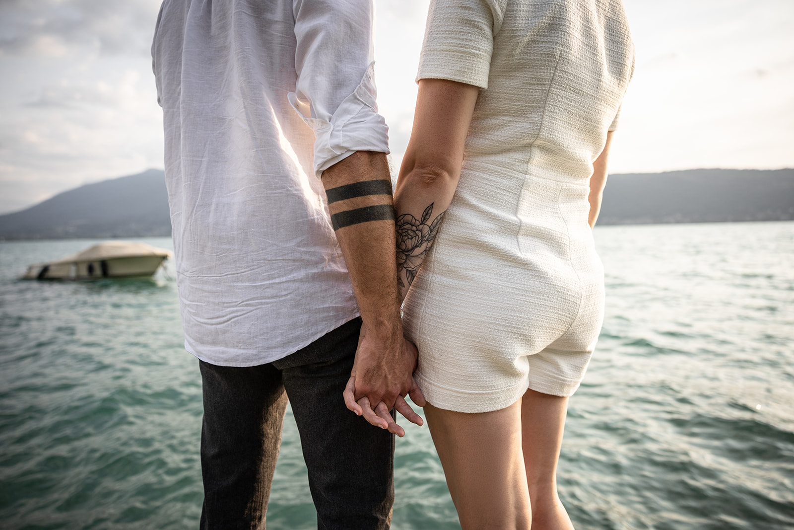 photo de détail d'un couple avec des tatouages sur le bras lors d'une séance photo au bord du lac d'Annecy