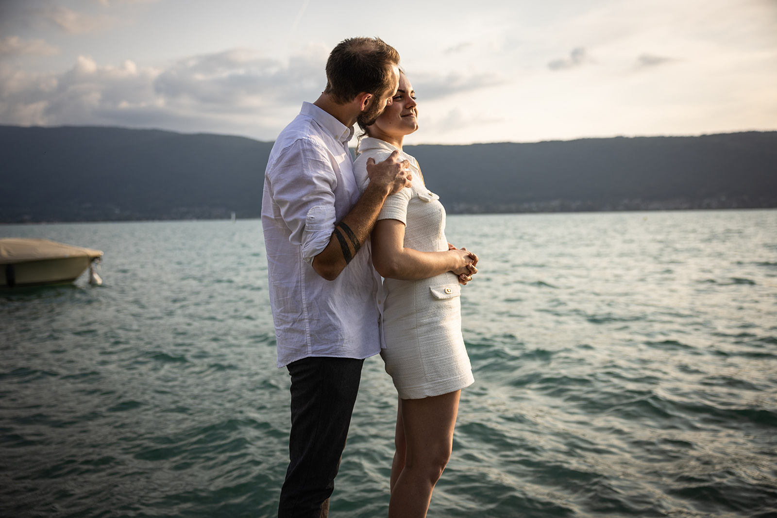couple qui s'enlace lors d'une séance photo au bord du lac d'Annecy