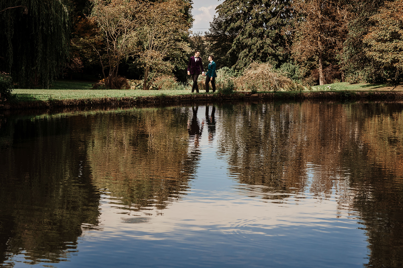 Newly married couple walk round lake at Mount Ephraim Country House & Gardens