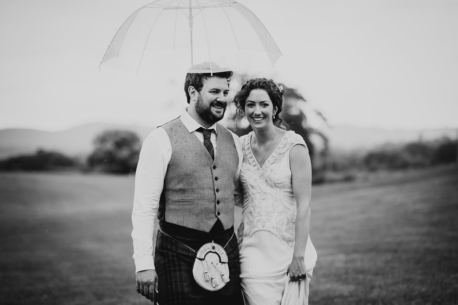 bride and groom under umbrella