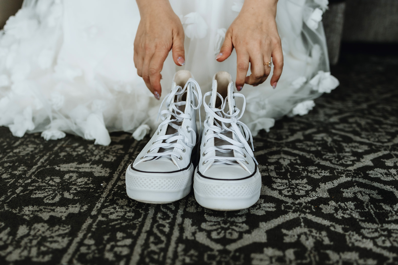 Detail shots of an Icelandic elopement. Bride is putting on her white sneakers for her adventure elopement in Iceland.