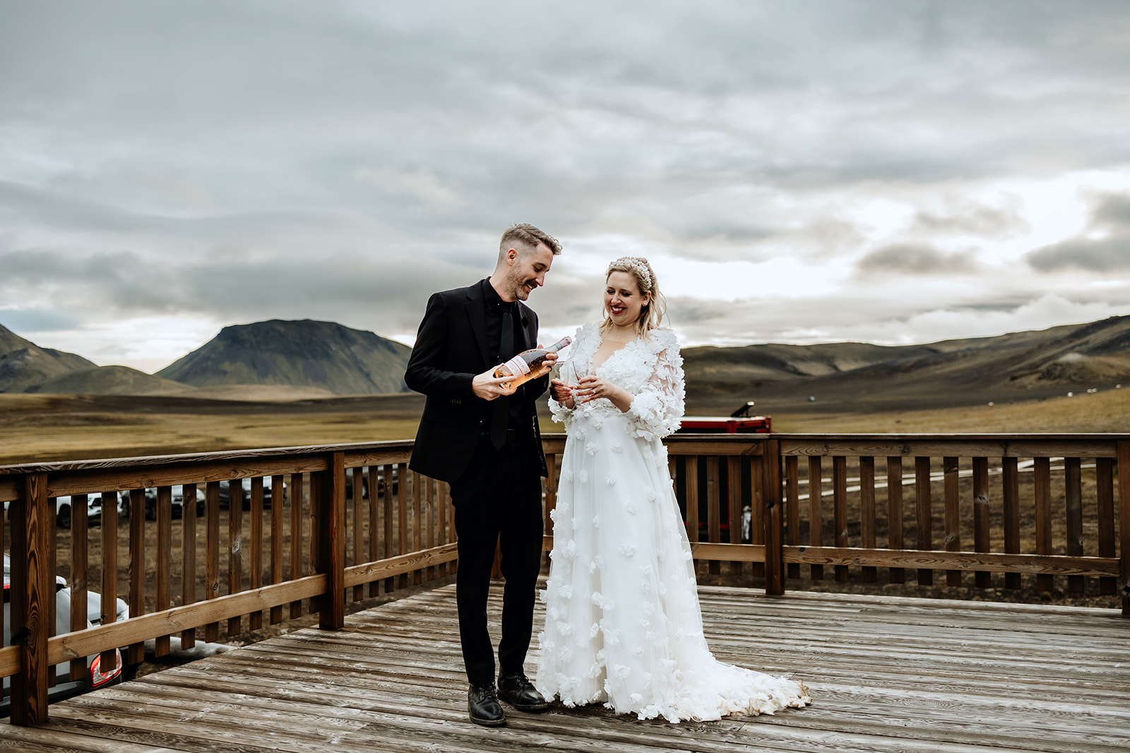 Bride and Groom are celebrating the end of their wedding day in Iceland with a bottle of champagne