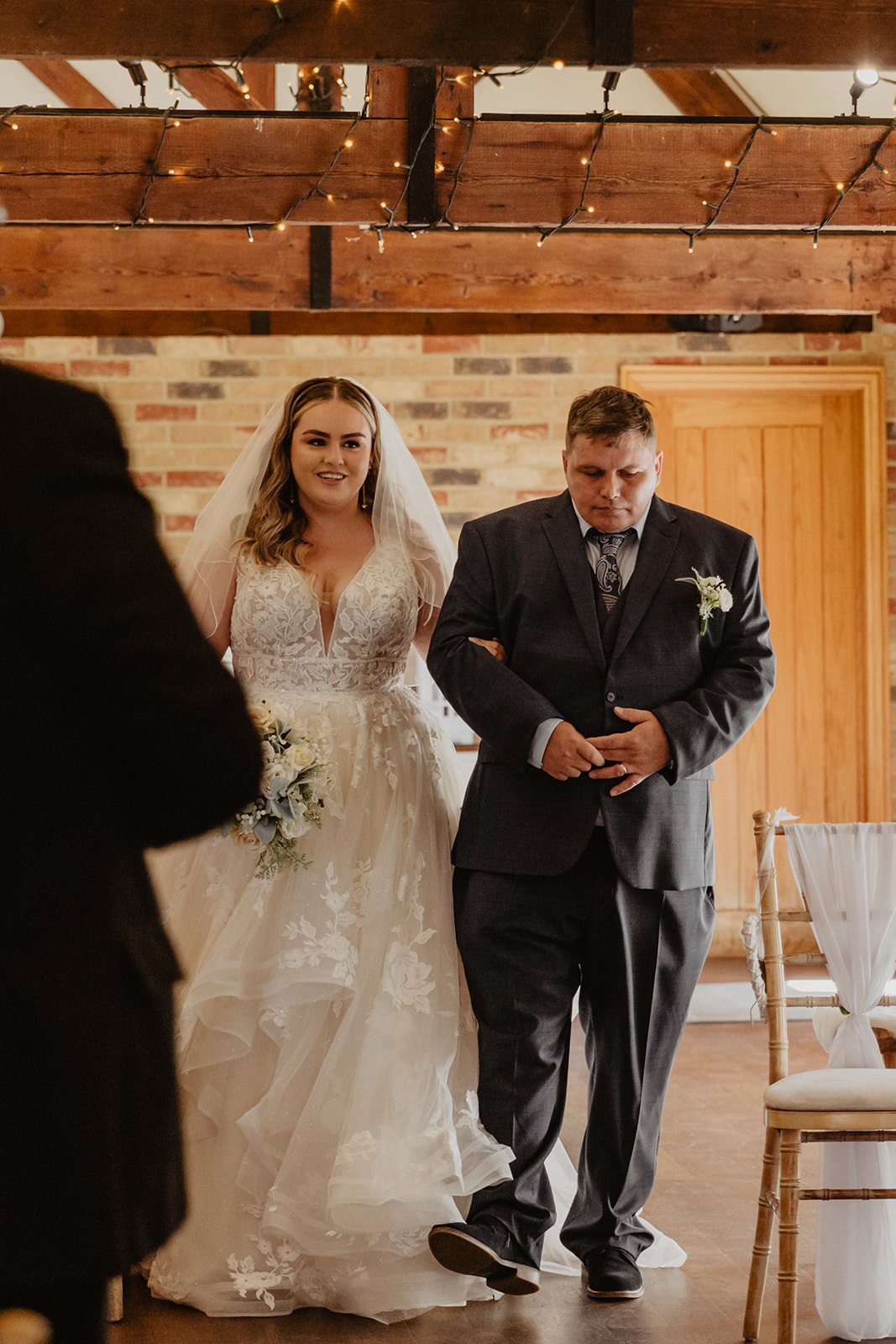 Bride being walked down the aisle at a Long Furlong Barn Wedding in Worthing, Sussex. By Olive Joy Photography.