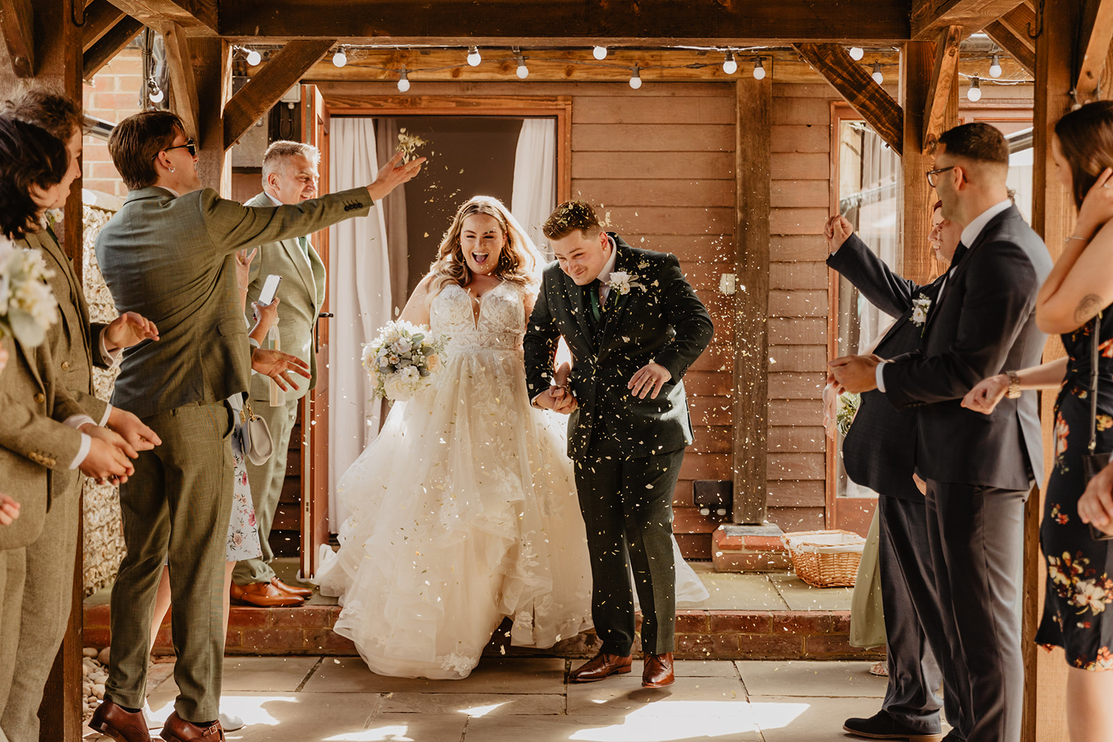 Bride and groom with confetti at a Long Furlong Barn Wedding in Worthing, Sussex. By Olive Joy Photography.