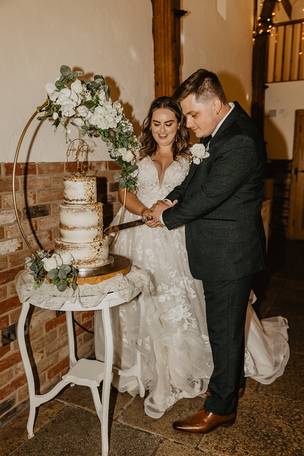 Bride and Groom cut their cake at a Long Furlong Barn Wedding in Worthing, Sussex. By Olive Joy Photography.