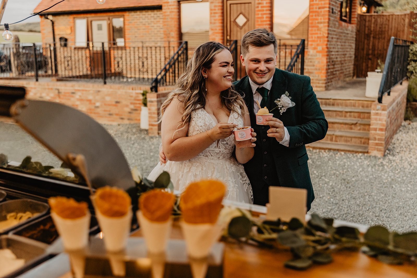 Bride and Groom eat ice cream at a Long Furlong Barn Wedding in Worthing, Sussex. By Olive Joy Photography.