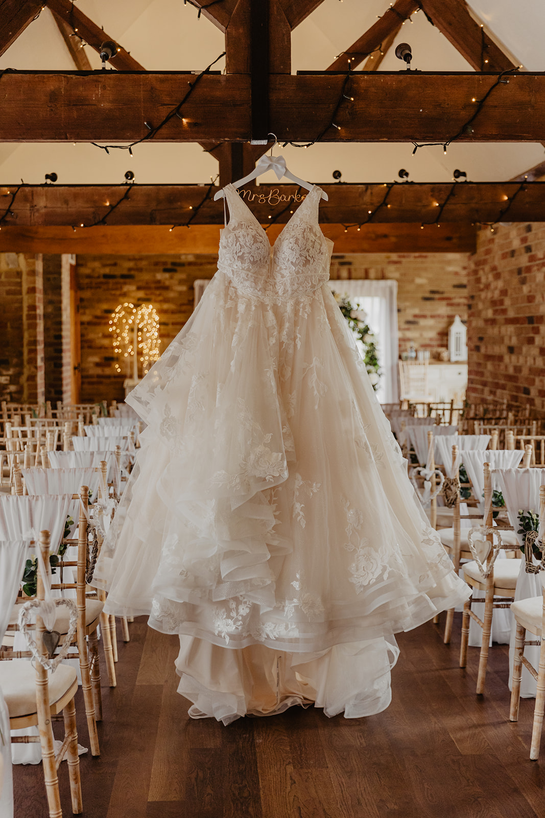 Wedding dress hanging up at a Long Furlong Barn Wedding in Worthing, Sussex. By Olive Joy Photography.