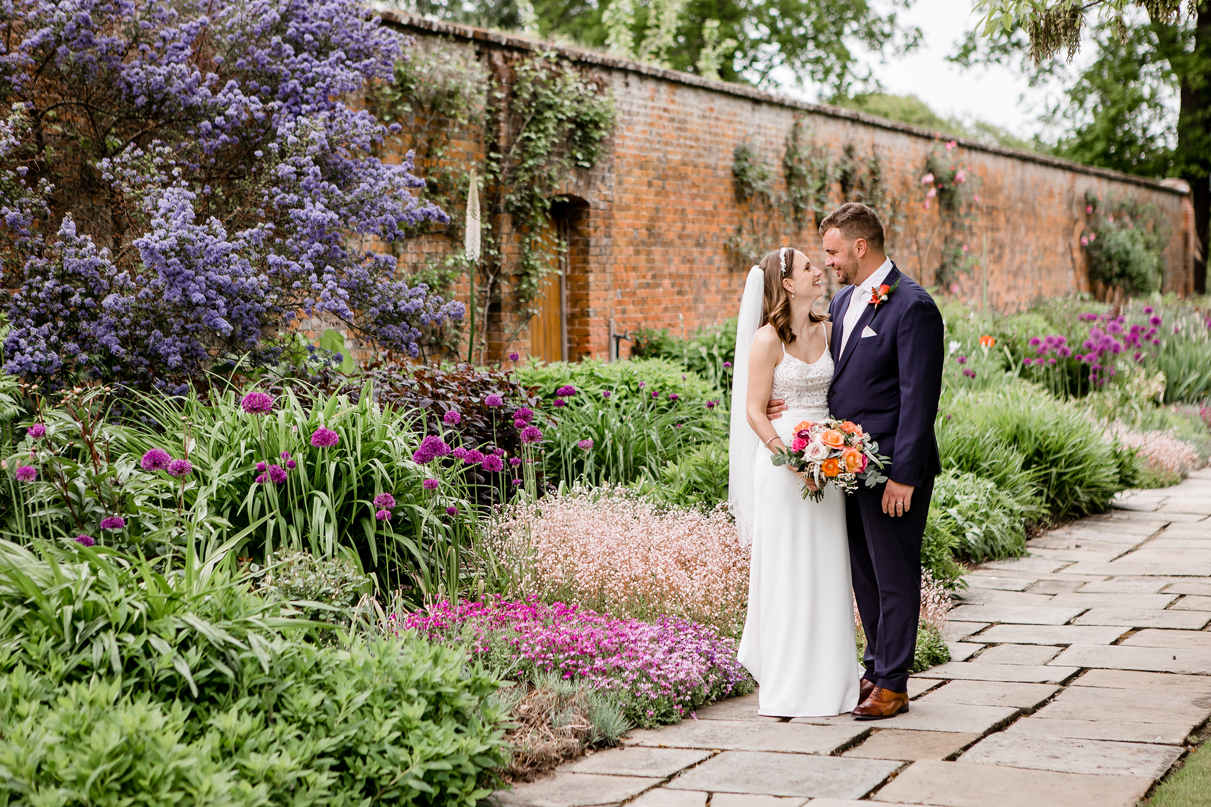 Bride and groom who got married at Blake Hall, kissing in the venues' secret garden
