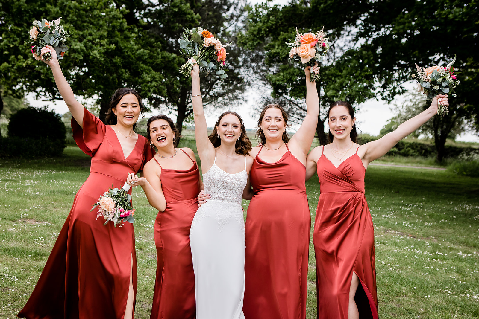 Bride and bridesmaids cheering with the wedding bouquets