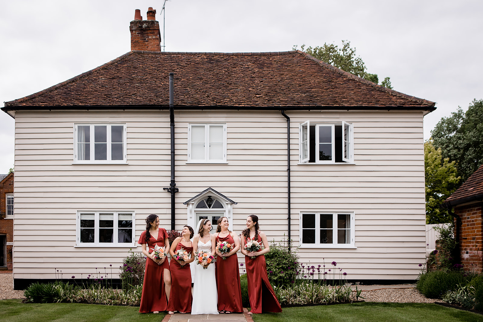 the bride and bridesmaids in their burnt orange dresses at Blake Hall