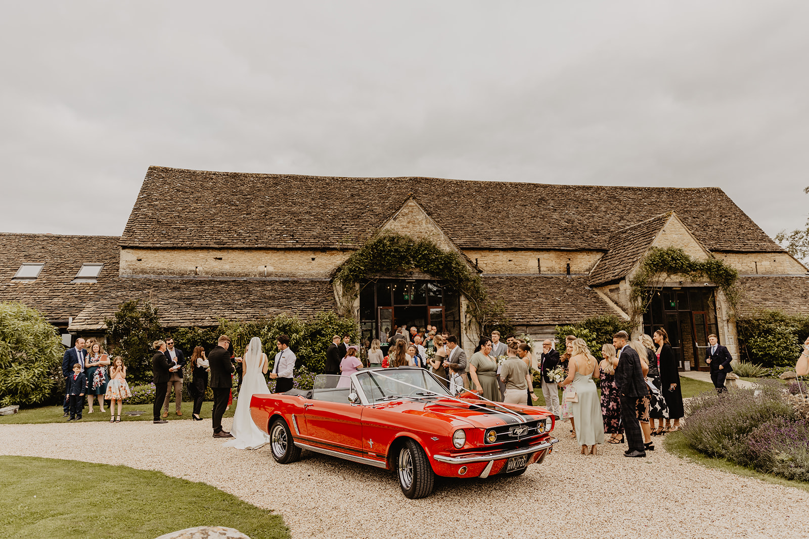 Bride and groom and their wedding car at a Great Tythe Barn Wedding, Cotswolds. By Olive Joy Photography.