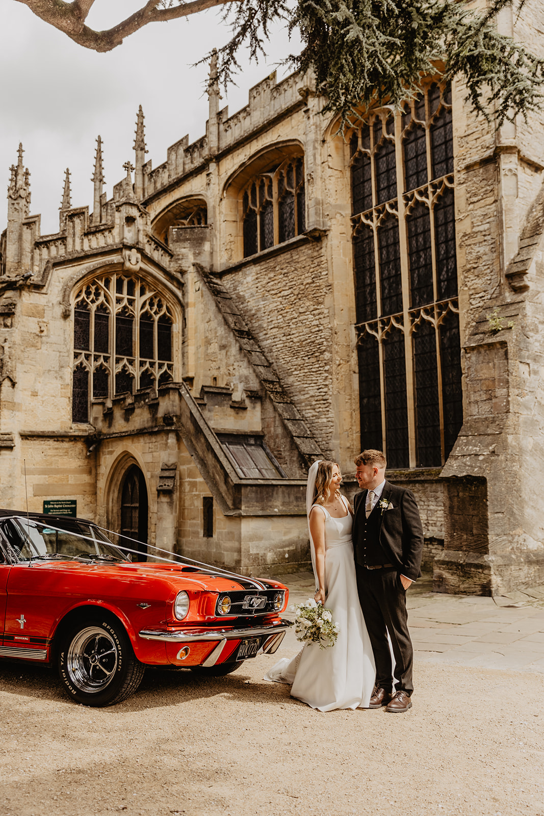 Bride and groom and their wedding car at a Great Tythe Barn Wedding, Cotswolds. By Olive Joy Photography.