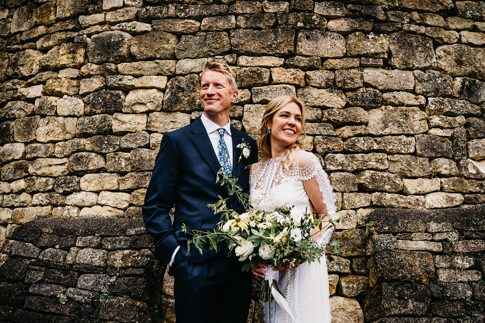 Bride and groom portrait with Cotswolds wall