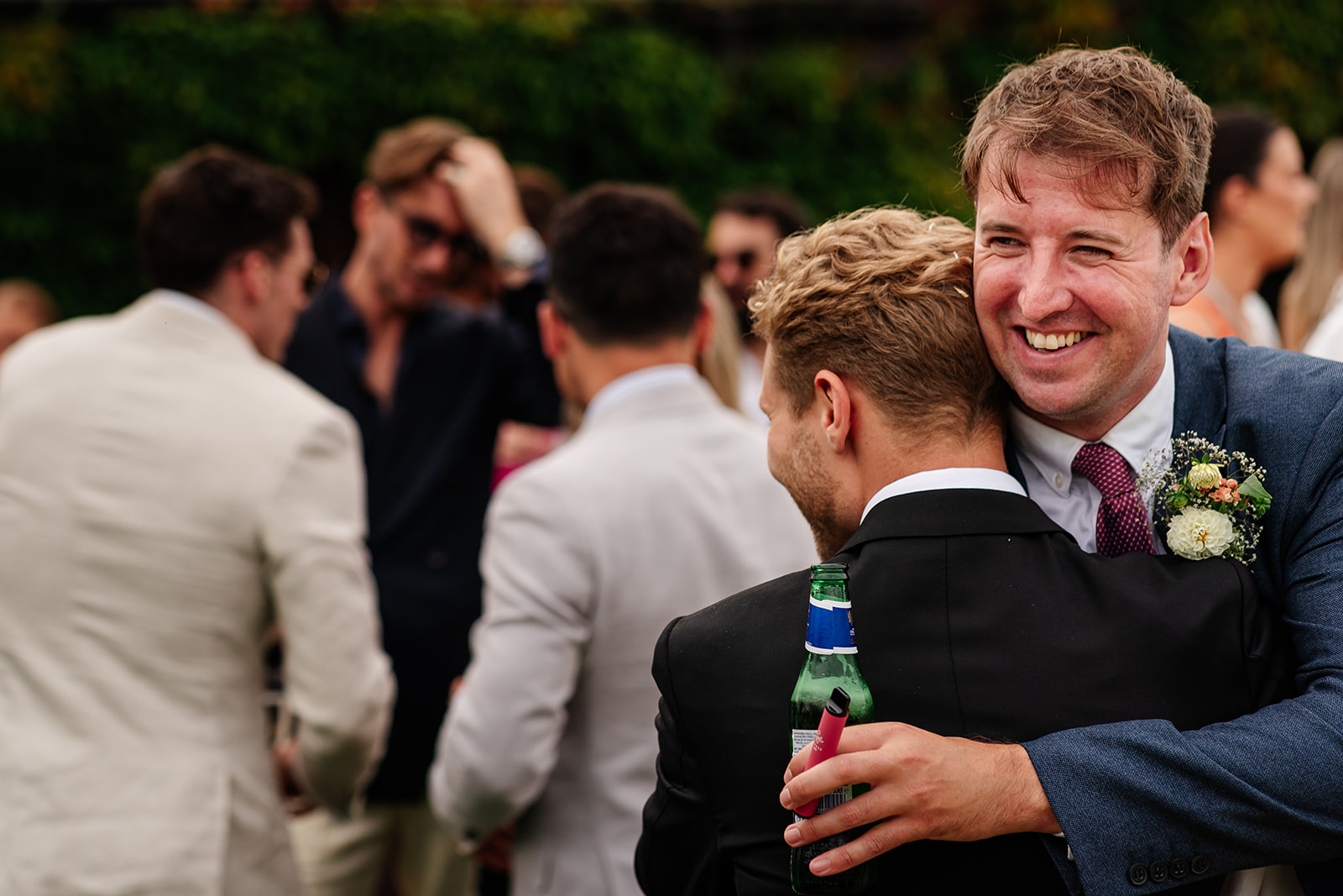 Guest hugging groom following the wedding ceremony 