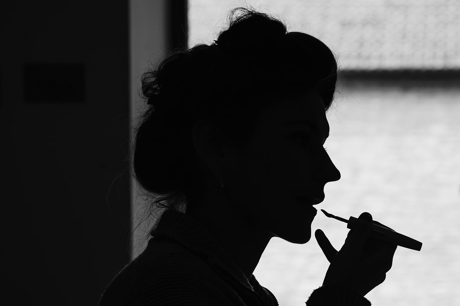 Silhouette of bridesmaid doing her make up 