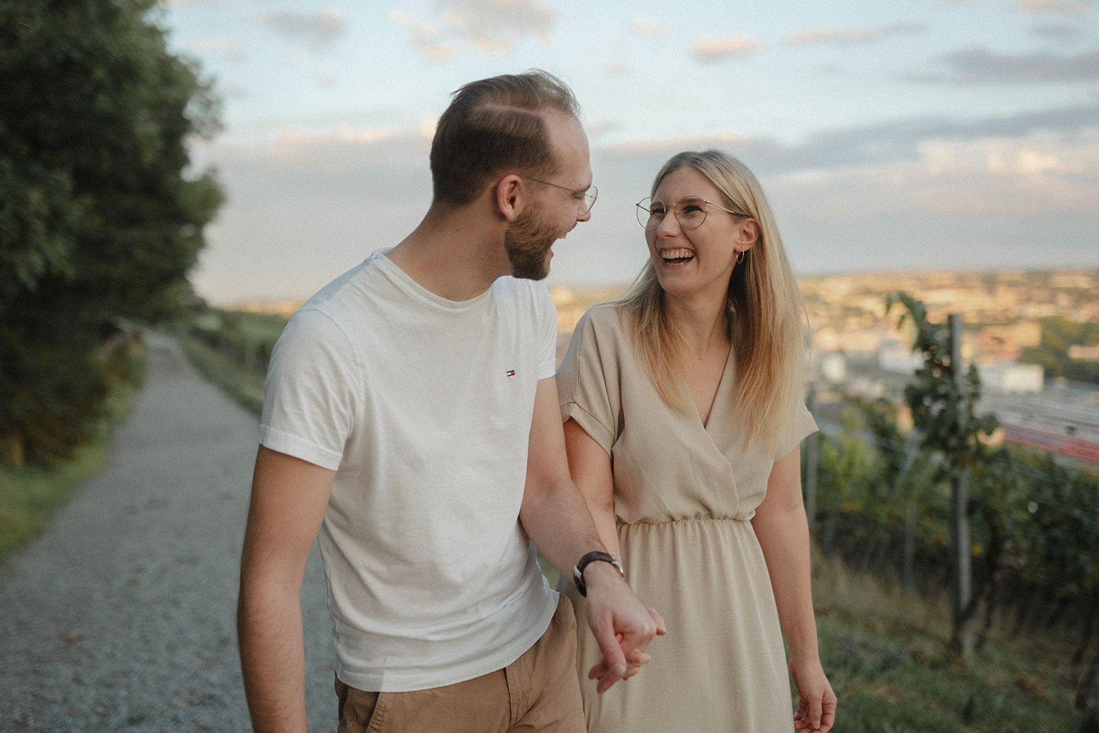 Ein Paar läuft lächelnd durch die Weinberg über Würzburg