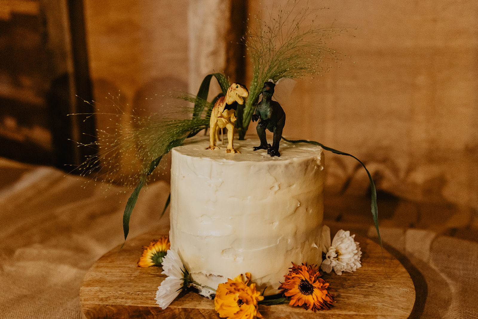 Wedding cake with dinosaurs at a wedding at Gilbert White's Hampshire. By OliveJoy Photography.