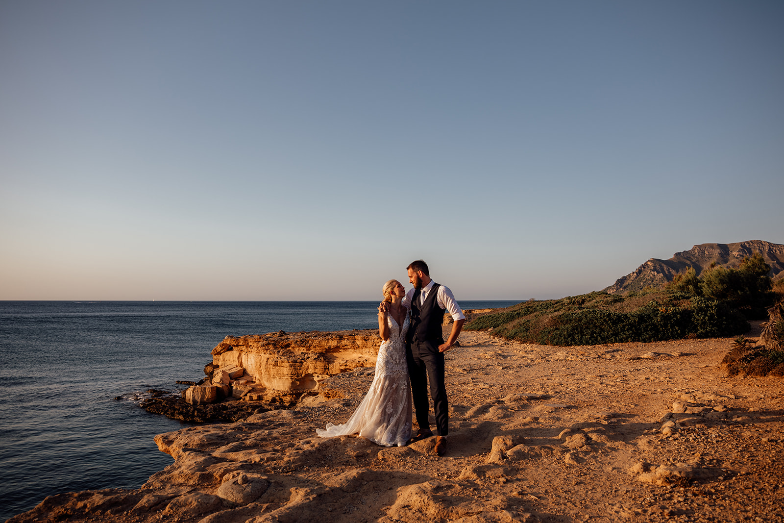 After Wedding Shooting Mallorca - Paar steht an Klippen und schaut sich an 
