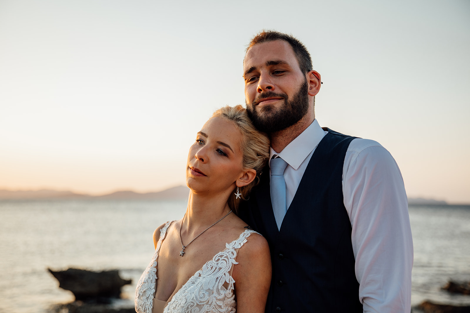After Wedding Shooting Mallorca - Braut lehnt an Bräutigam an - im Hintergrund Meer 