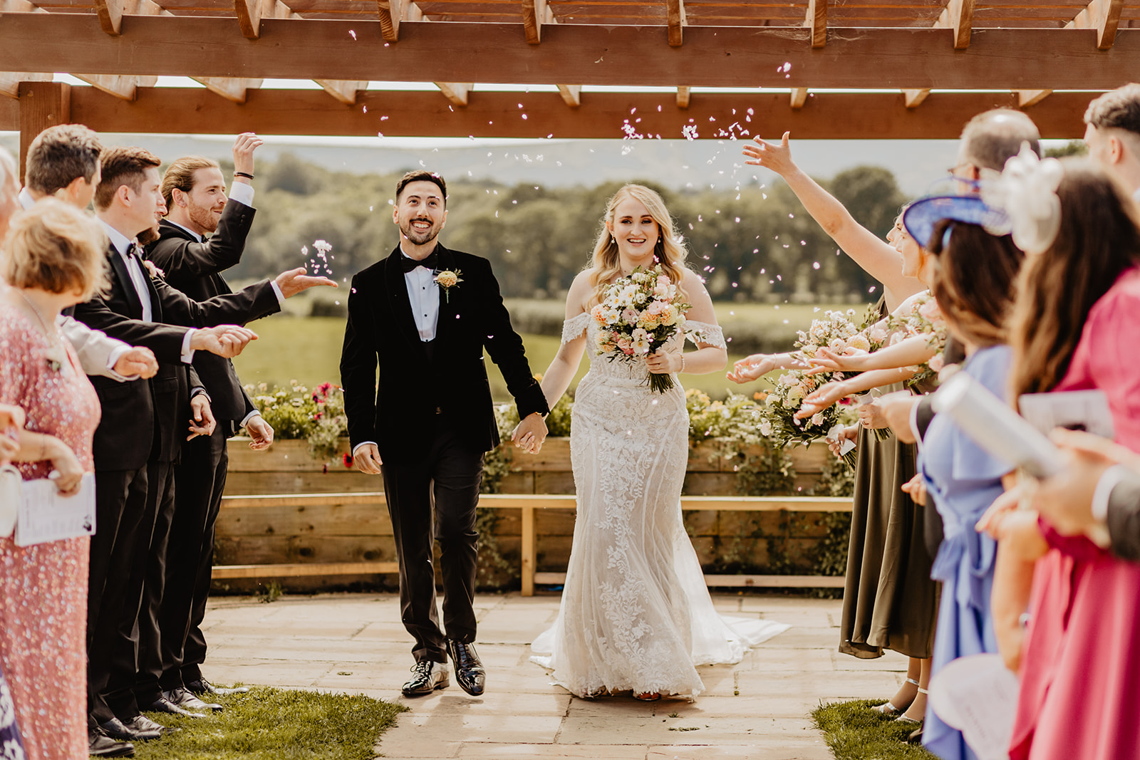 Bride and groom with confetti at a Southlands barn wedding, Sussex. Photo by OliveJoy Photography.