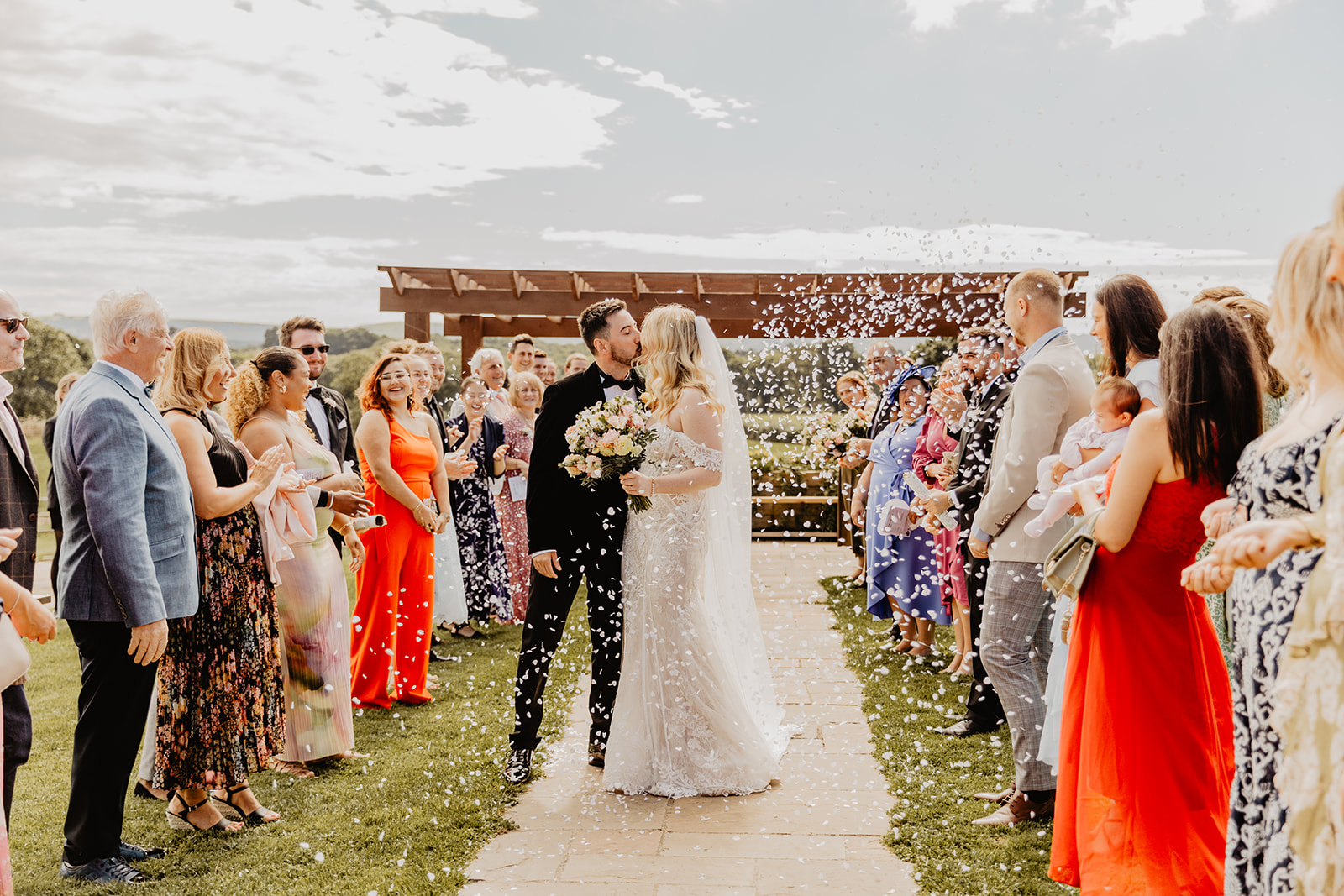 Bride and groom with confetti at a Southlands barn wedding, Sussex. Photo by OliveJoy Photography.