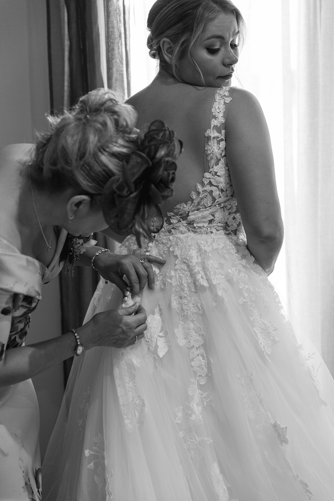 Bride getting into her dress at a wedding at Long Furlong Barn, Sussex. By OliveJoy Photography.